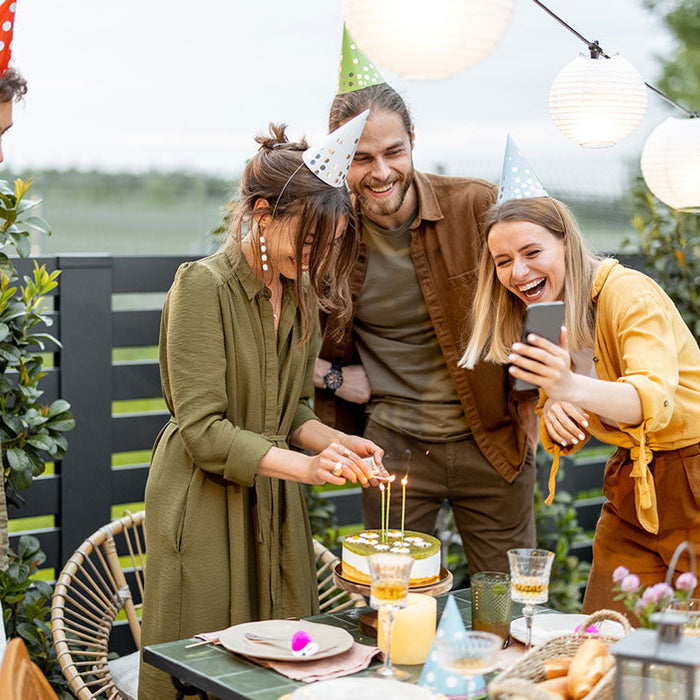 Anniversaire adulte entre amis ! Ils prennent des photos autours d'une table d'anniversaire