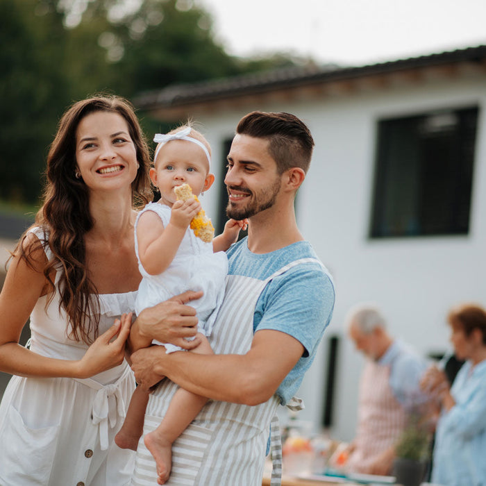 Photo article budget baptême, famille avec enfant en robe blanche. Repas de famille.