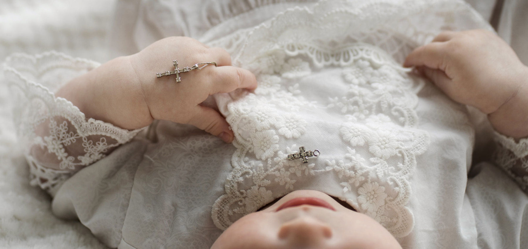 Enfant dans rode de baptême avec chapelet dans la main
