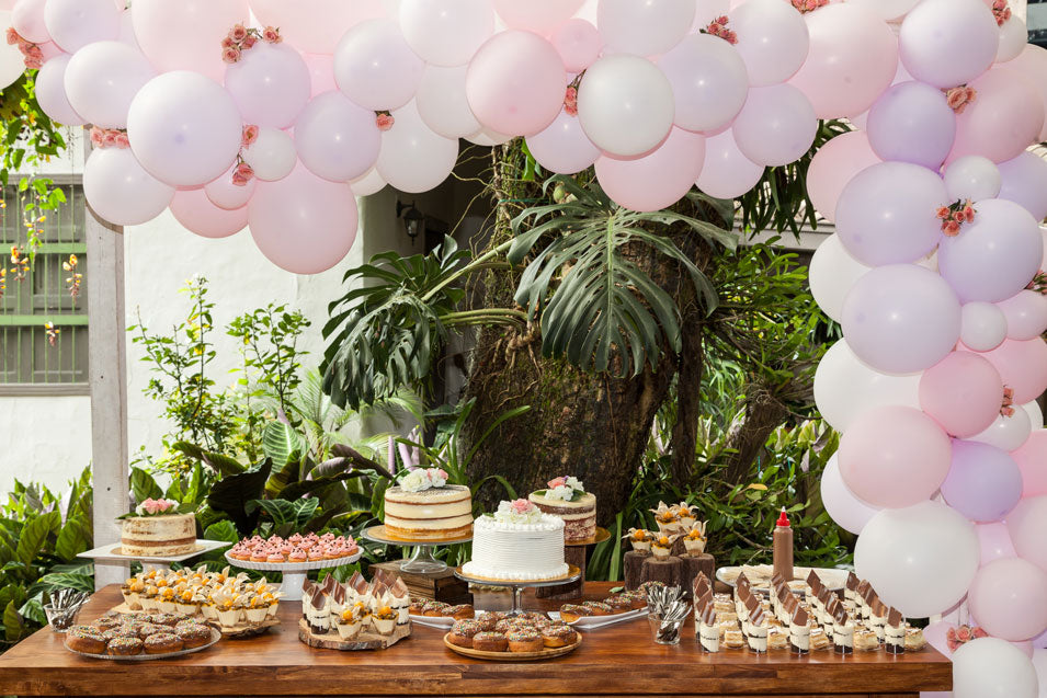 Table pour buffet sucré, avec arche de ballons pour un baptême