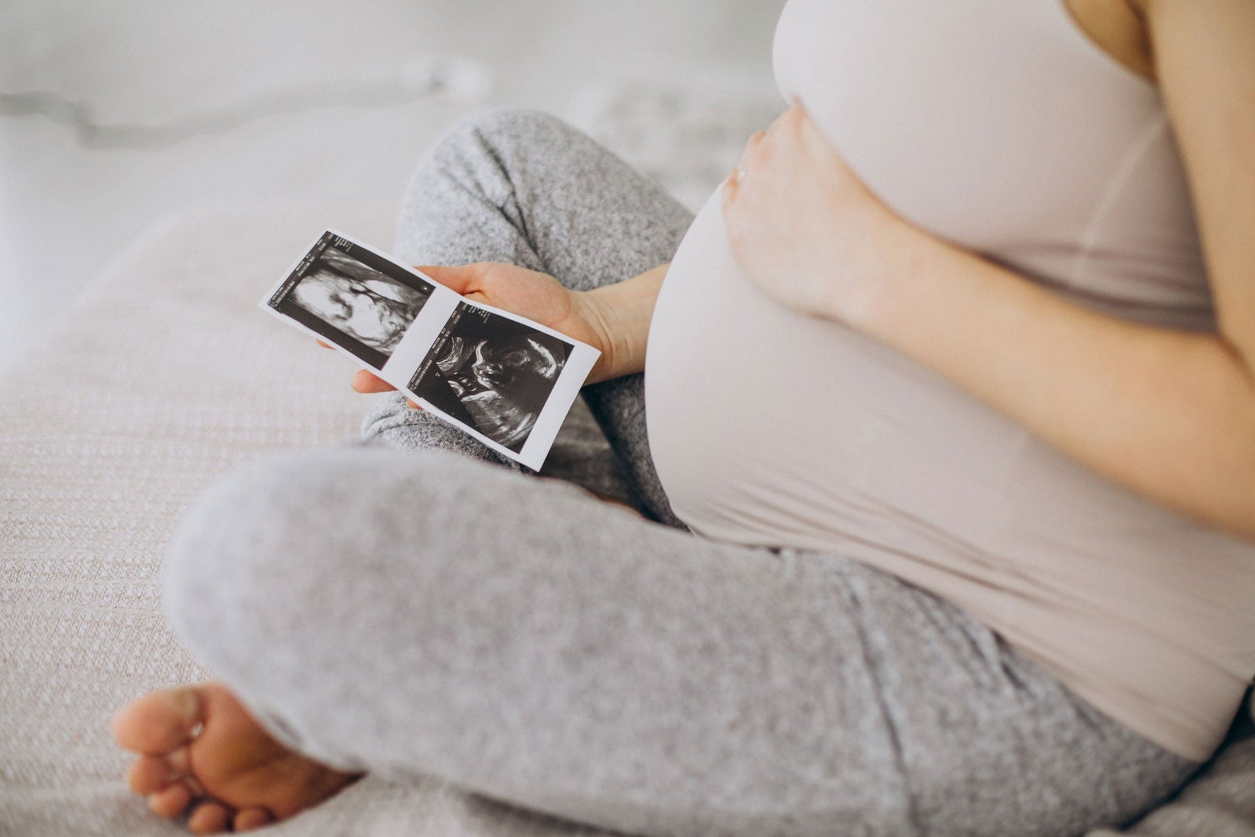 Femme enceinte assise avec échographie dans le main