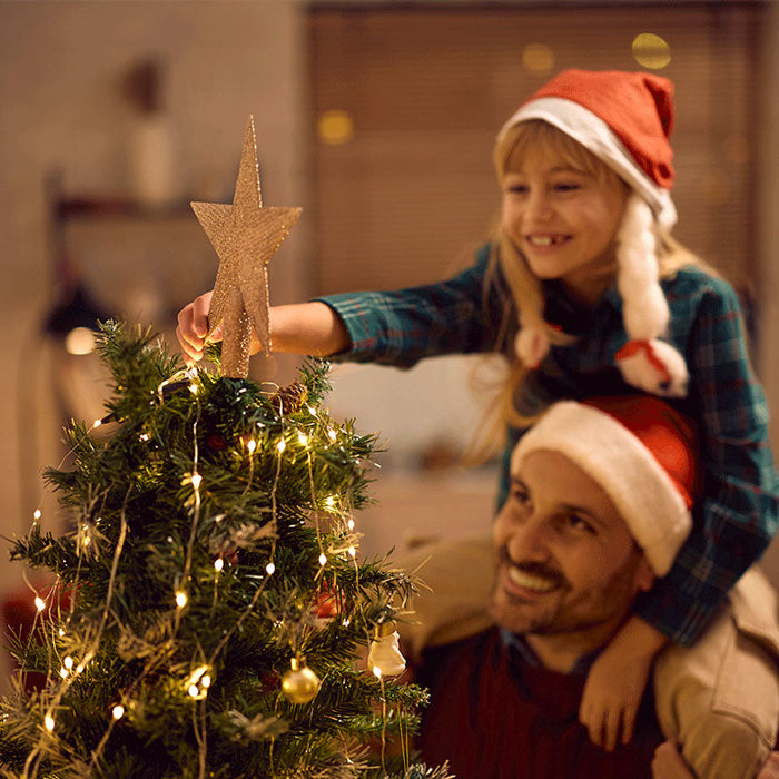 Fille et son papa entrain de décorer le sapin de Noël