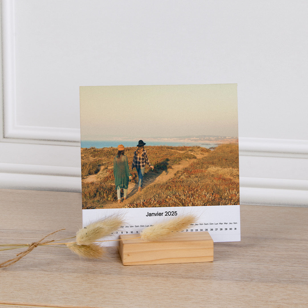 Calendrier avec support bois au format carré, ouvert sur le mois de janvier 2025 avec la photo d'un paysage avec deux personnes et la grille du mois de janvier 2025.