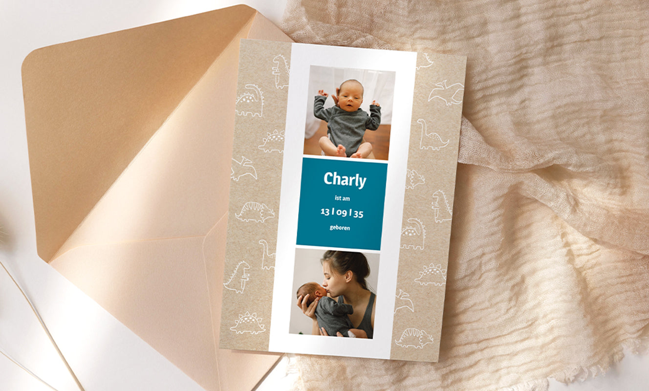 Foto mit einem beigefarbenen Laken und Umschlag im Hintergrund einer kraftvollen Geburtsanzeige im Hochformat mit weißen Dinosauriermotiven, zwei Babyfotos und einem Text in der Mitte „Charly est né le 13/09/35“.